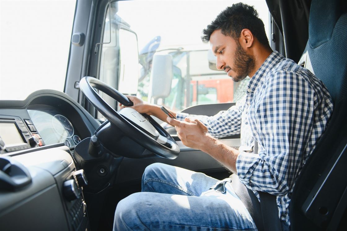 A person in a truck using his phone

Description automatically generated